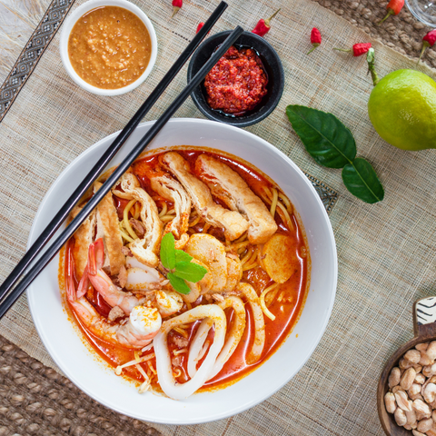 Curry laksa is a popular rice noodle dish with a base of red coconut curry soup with added seafood and chicken
