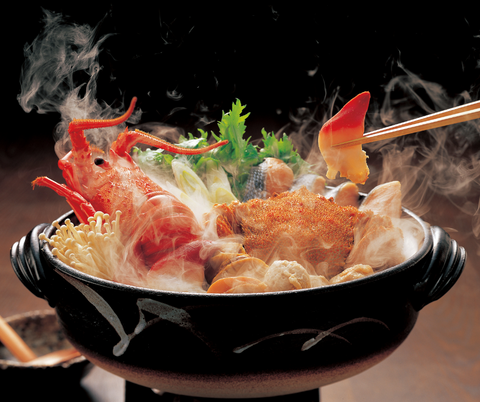 A seafood hotpot loaded with fish balls, sliced meat and vegetables cooked on the table with everyone
