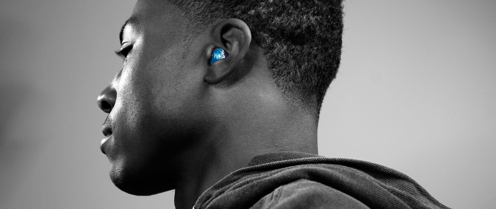 Man wearing blue custom molded earplugs