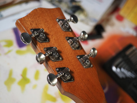 open tuners on a guitar headstock