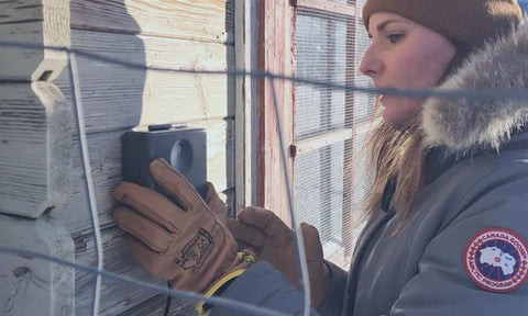 Woman installing Omlet control panel for coop door