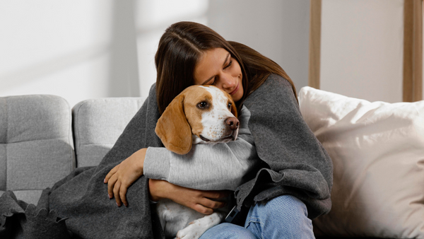 Woman owner cuddling with dog