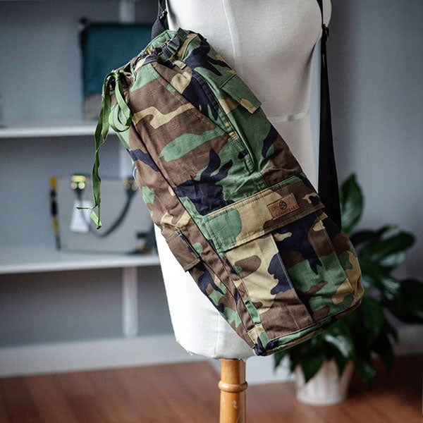 Made to order yoga bag handcrafted from upcycled military uniform hanging on a mannequin. 