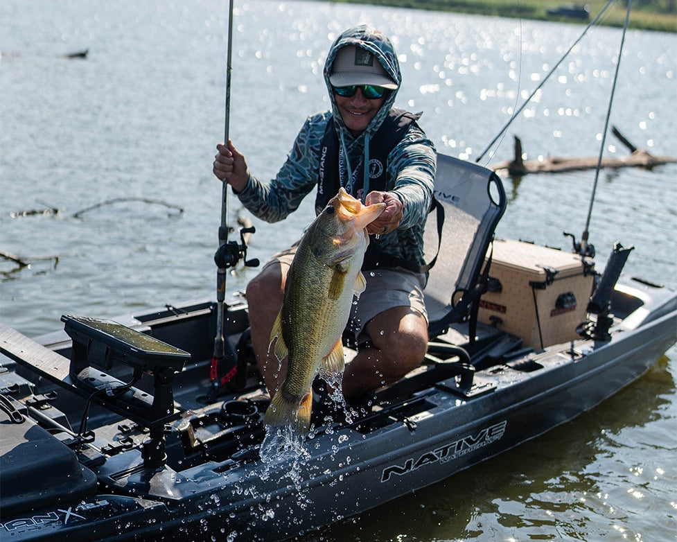 Angler pulling fish out of water, sitting in Propel 10.5