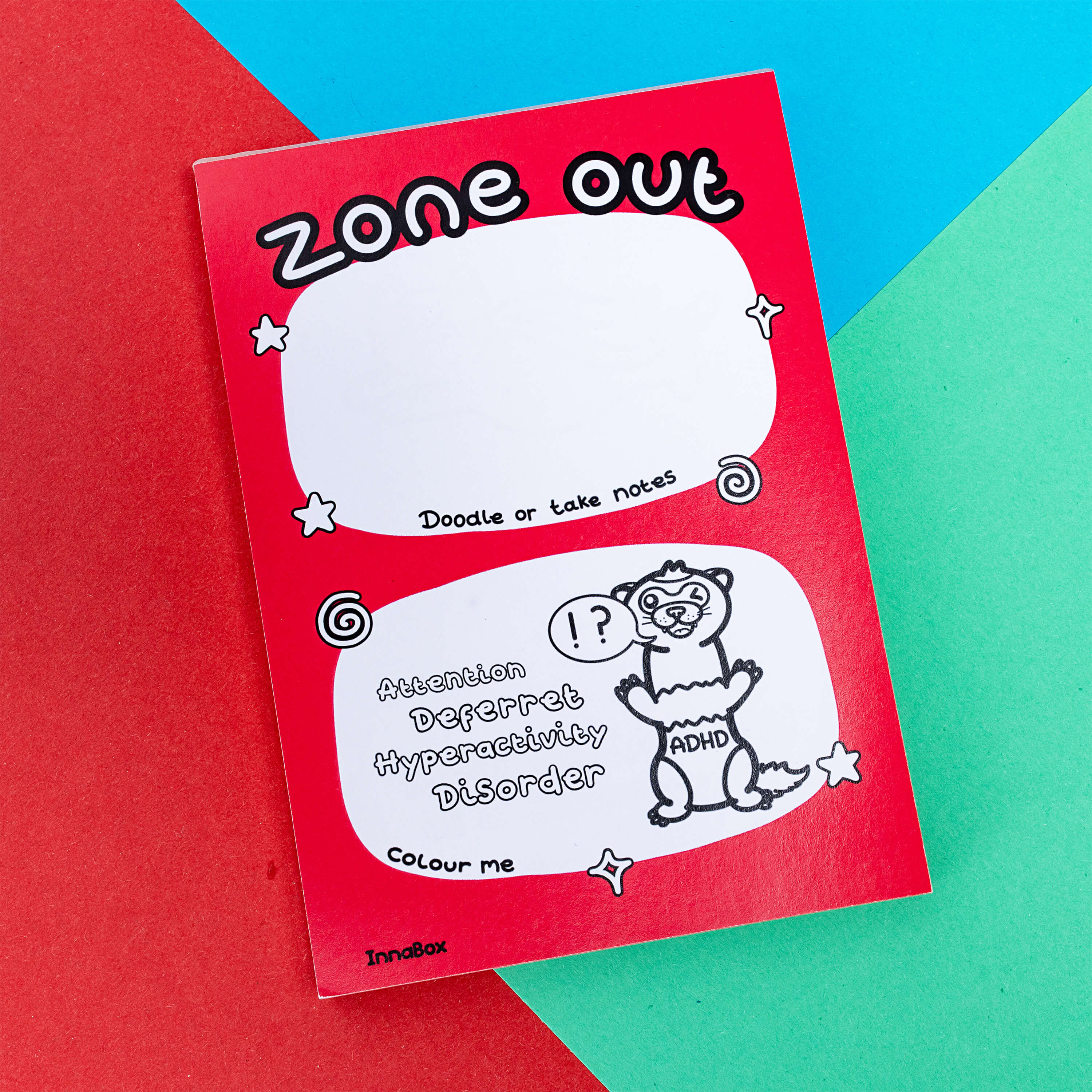 A look at the one out notebook there is a ferret with ADHD written on its tummy and the words 'Zone out' on the top it is on a blue, green and red background