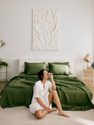 woman lounging in her bedroom wearing her linen nap dress 