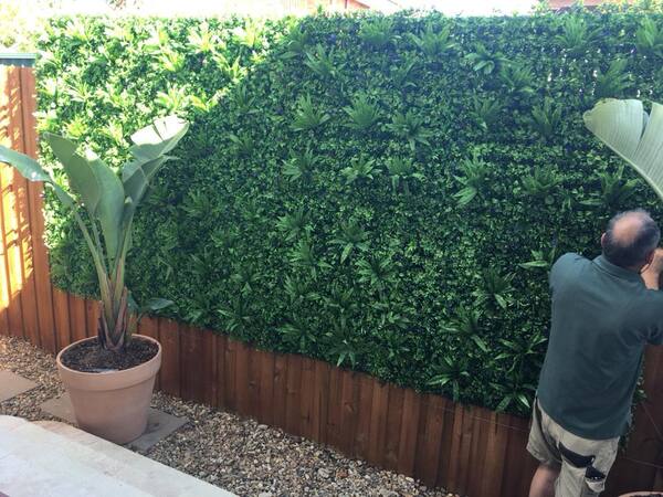 the process of installing faux hedge panels