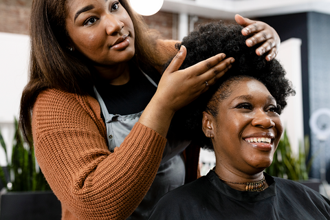 hairstylist prepping client's hair for braiding