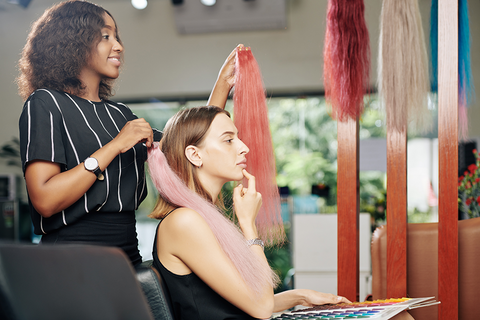 hairstylist showing color extensions to customer