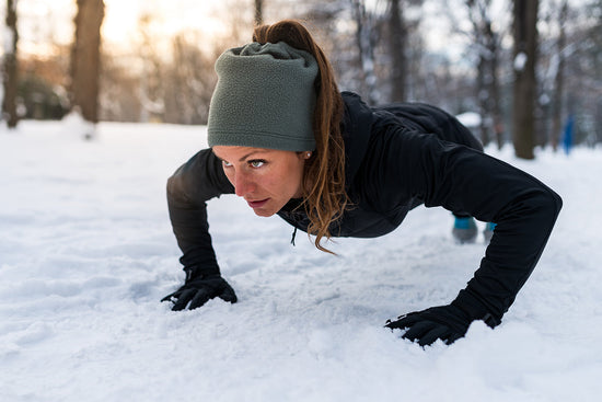 Una donna fa flessioni in mezzo alla neve