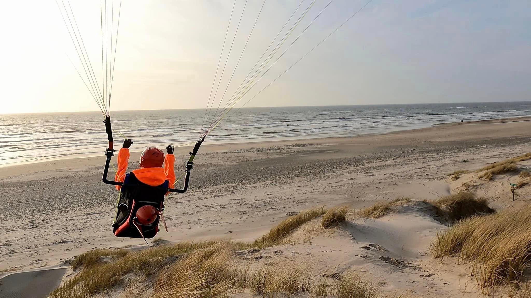 RC Gleitschirm Liegegurtzeug Rocket fliegt am Meer einer Düne entlang