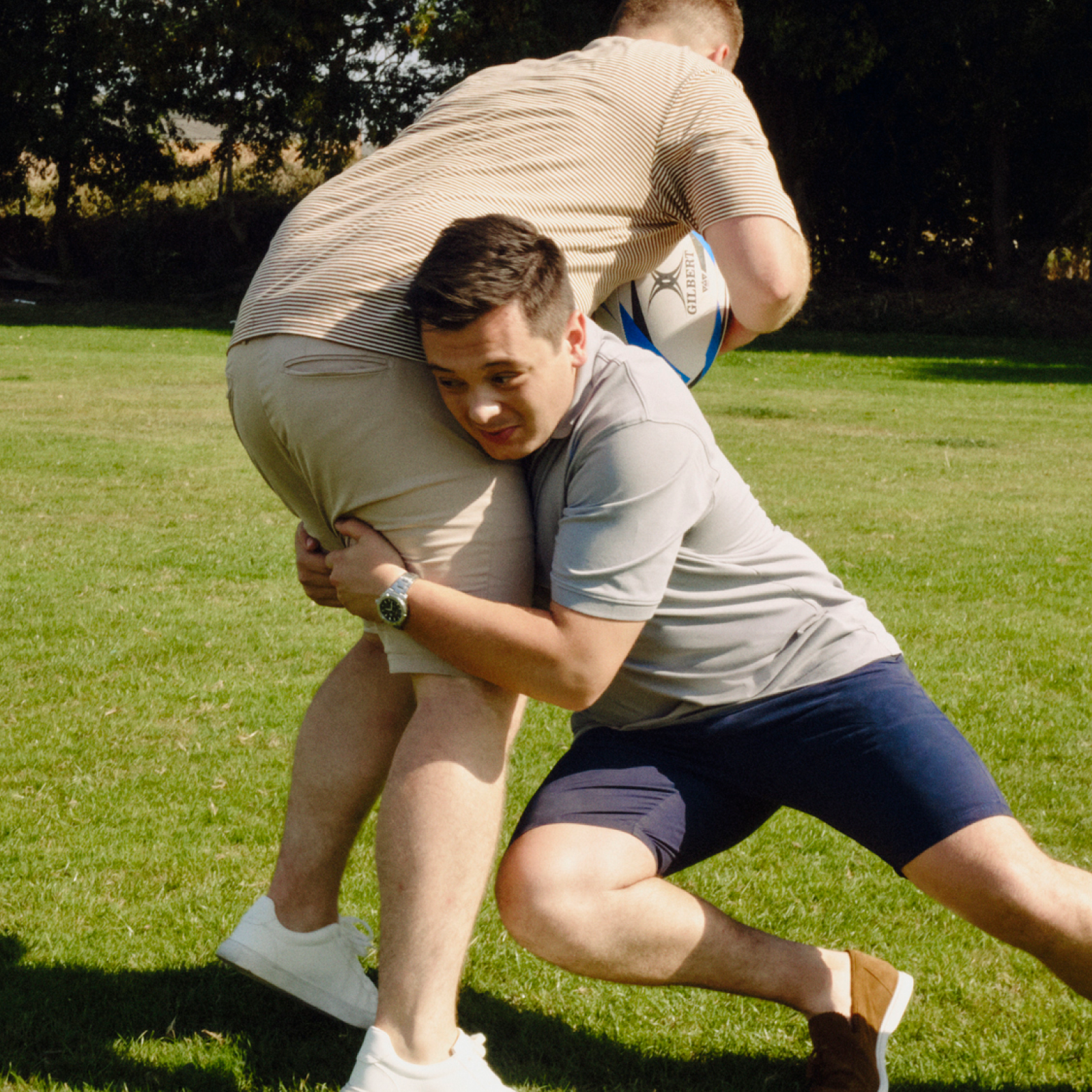 Two rugby players fiercely battling for possession of the ball