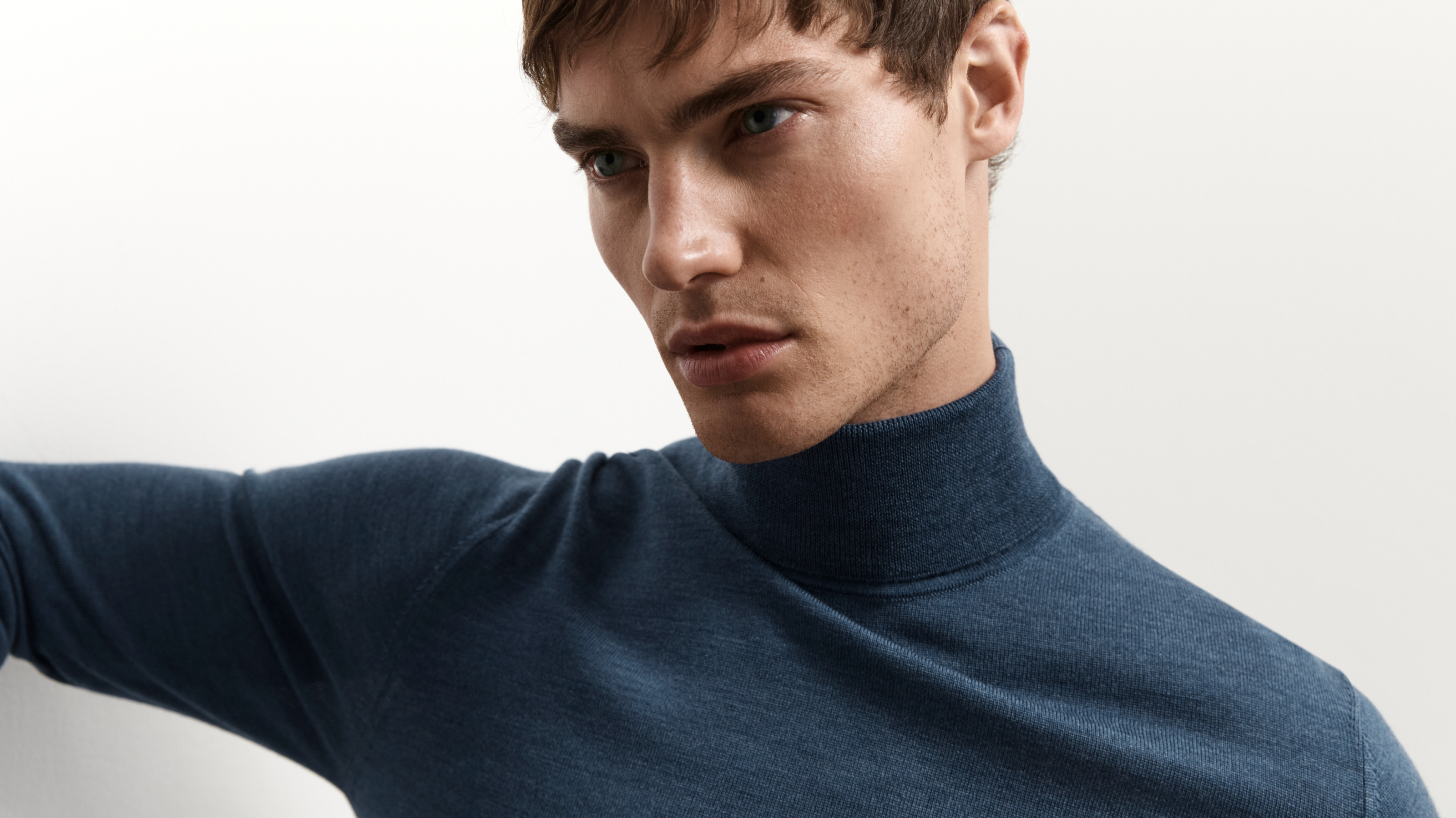 A man wearing a denim roll neck jumper