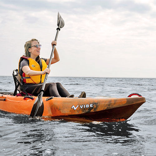 Femme pagayant en kayak Yellowfin 100 orange dans le golfe du Mexique