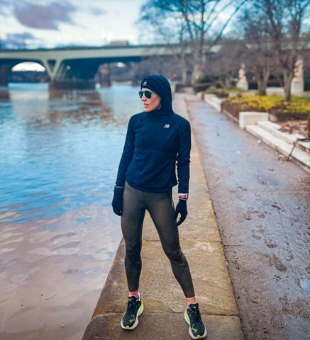 female runner wearing stabilyx tights in forest nights layering up with a running jacket