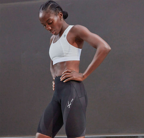 female athlete recovering after workout wearing CW-X compression leggings