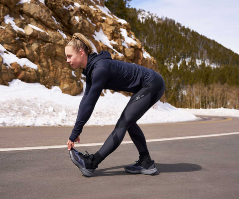 female athlete doing a stretch wearing endurance generator insulator tights