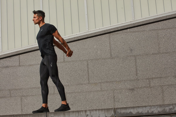 male athlete resting doing an arm stretch