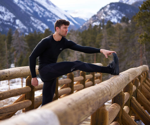male athlete stretching before a day of skiing in endurance generator insulator tights