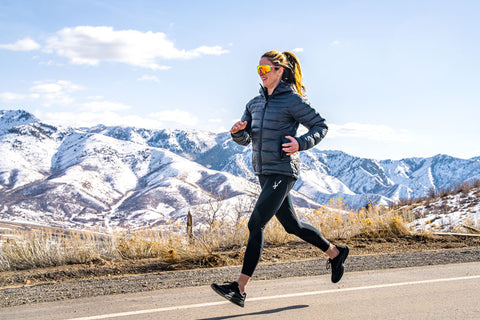 woman running outdoor in the winter wearing CW-X Compression Pants