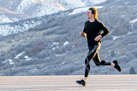 man running in wintery outdoor wearing CW-X compression pants model Stabilyx