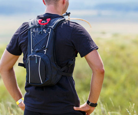 male athlete with hydration system on back for running