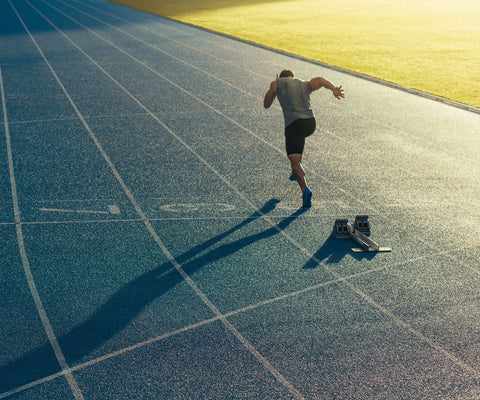 male athlete training for a marathon running on a track