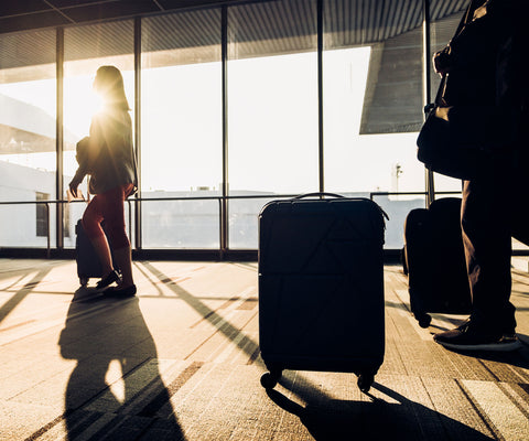 travelers in compression gear waiting to board their flight with suitcases