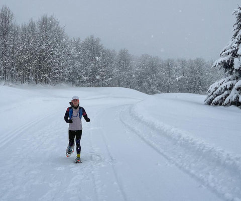 athlete running in cw-x tights in the snow