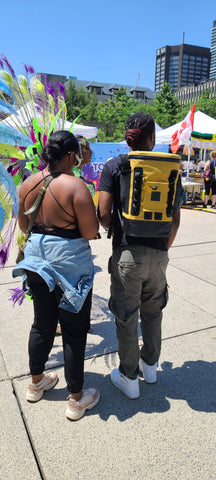 My friend Courtney carrying my backpack for me while I was in costume at the Toronto Caribbean Carnival launch event.