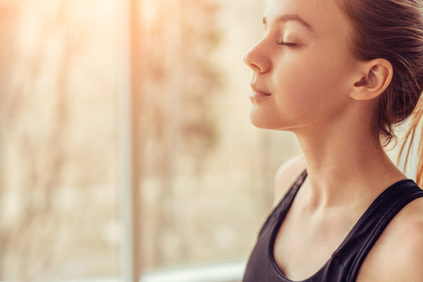 Young woman doing breathing exercise stock photo