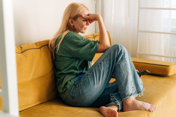 woman sitting on couch, fatigued