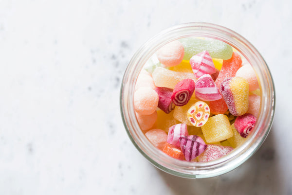 a jar of candy on a marble surface