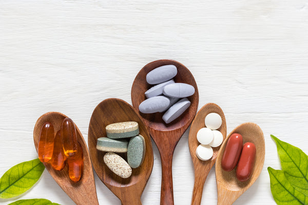 different types of dietary supplements on wooden spoons