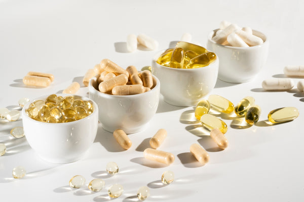 variety of vitamins and supplements in bowls and on a surface