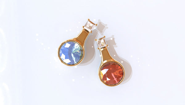 Two stud earrings resembling RPG potion bottles. One with a light blue gem, and the other with a red gem.