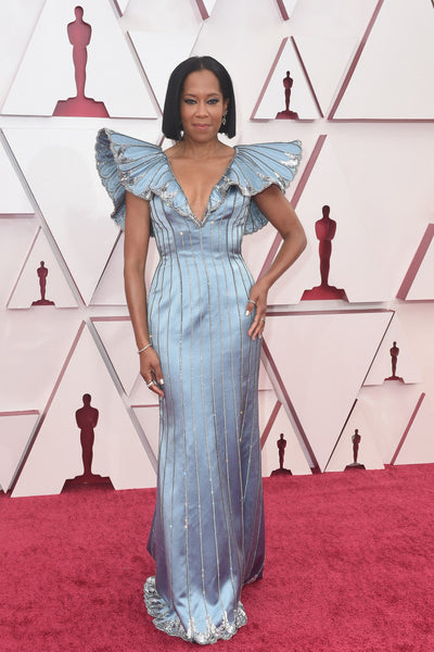 Regina king wearing a light blue gown by Louis Vuitton. The structured shoulders flare out and up and feature quilted shapes that resemble feathers.