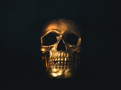 A golden skull against a black background.