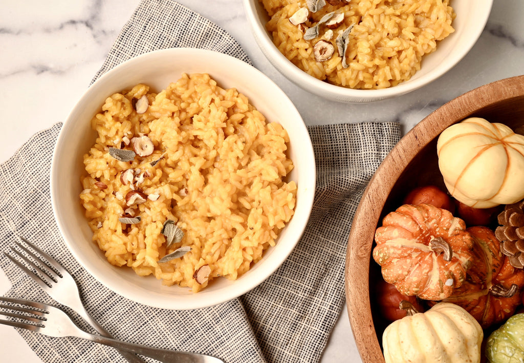 A bowl of pumpkin risotto next to two forks