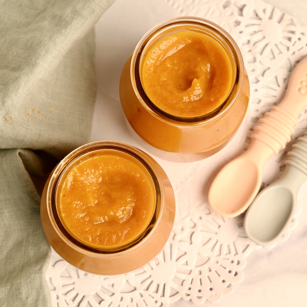 An above view of baby food puree in glass jars