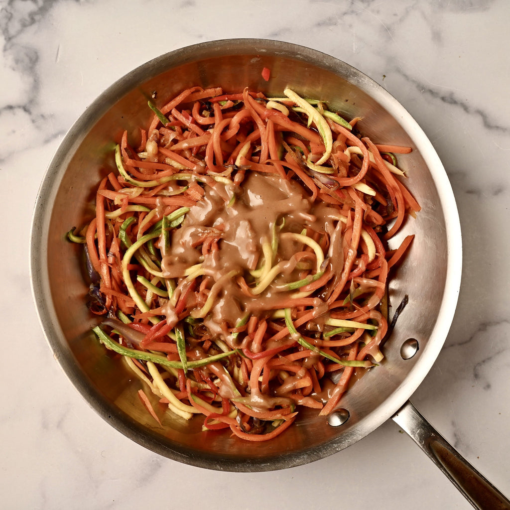 A bowl of carrot zoodles in a stir fry sauce