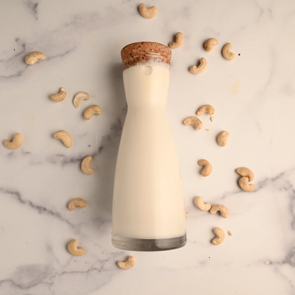 A glass container of cashew milk