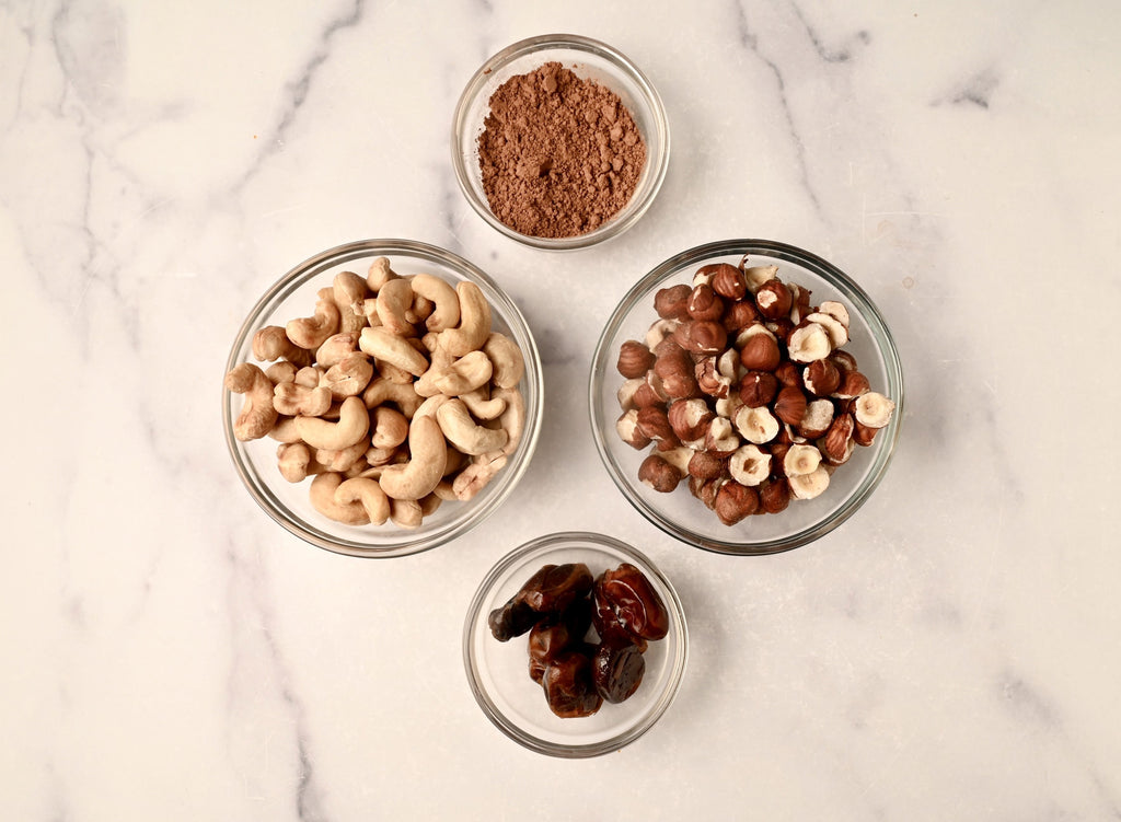 A clear glass bowl filled with raw cashews