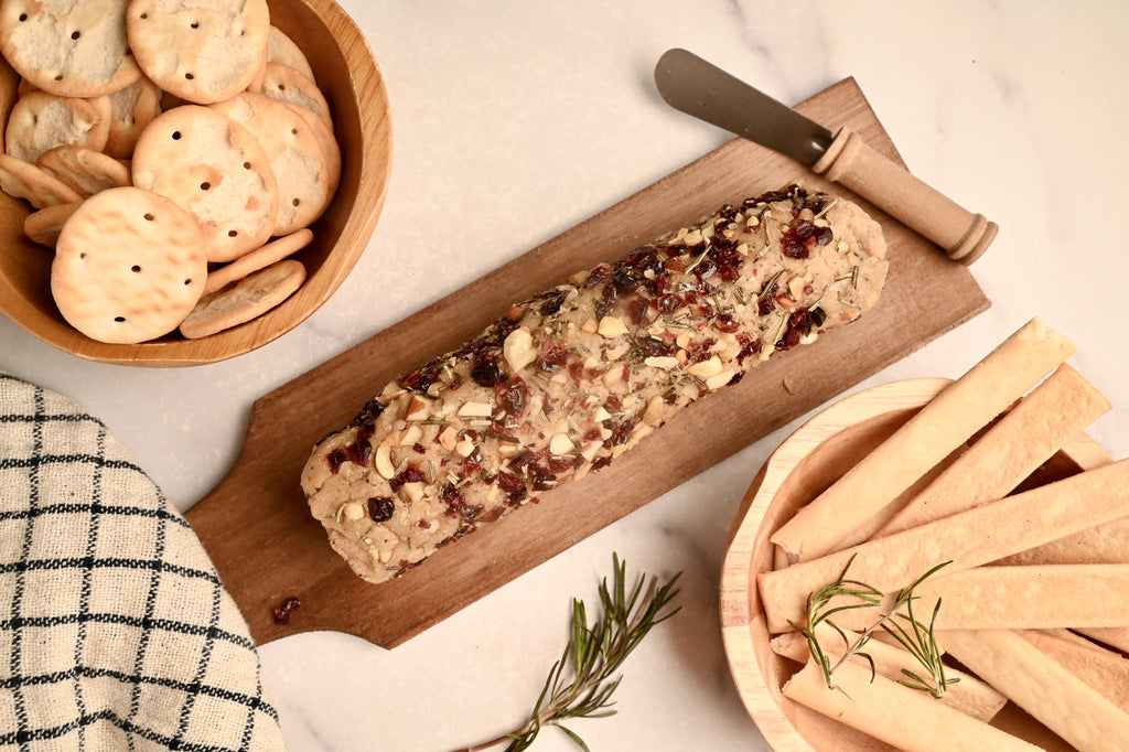 An above view of a cheese log next to a bowl of crackers