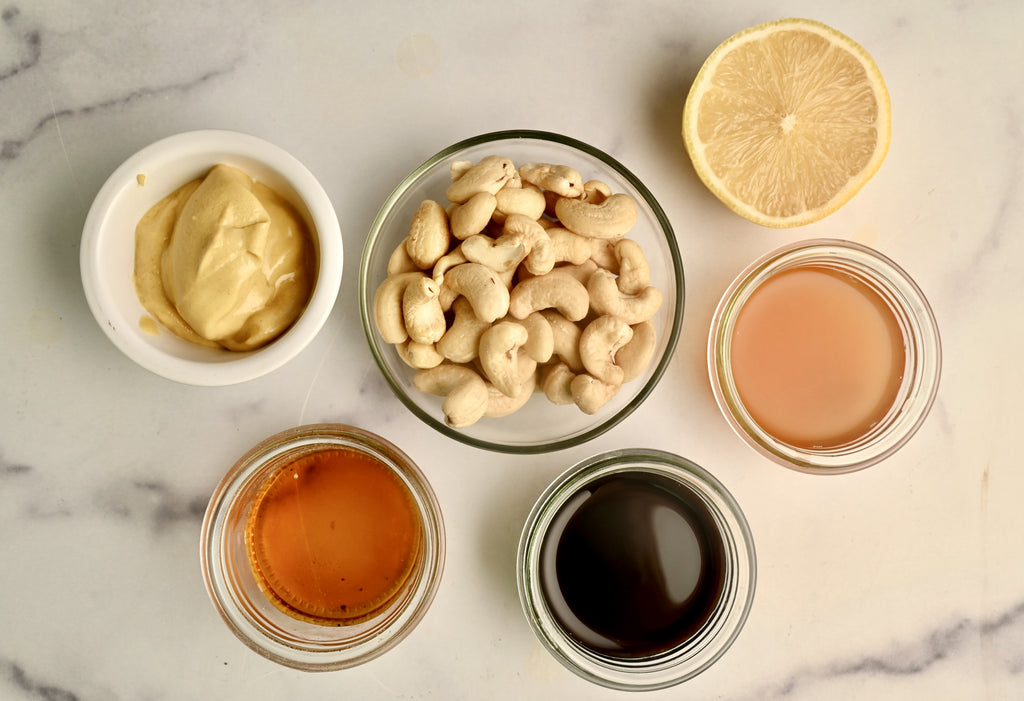 Raw salad dressing ingredients in small clear glass bowls