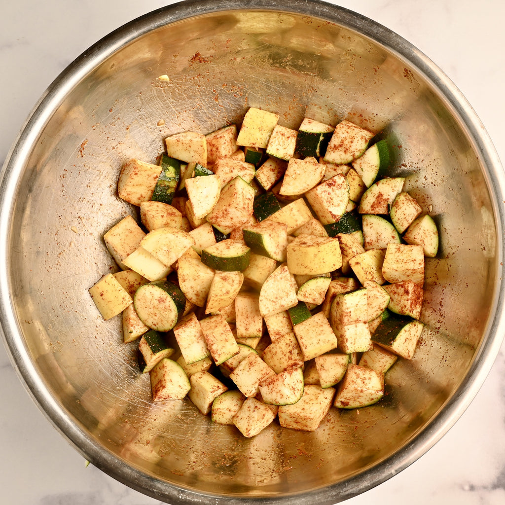 Raw zucchini diced in a large mixing bowl