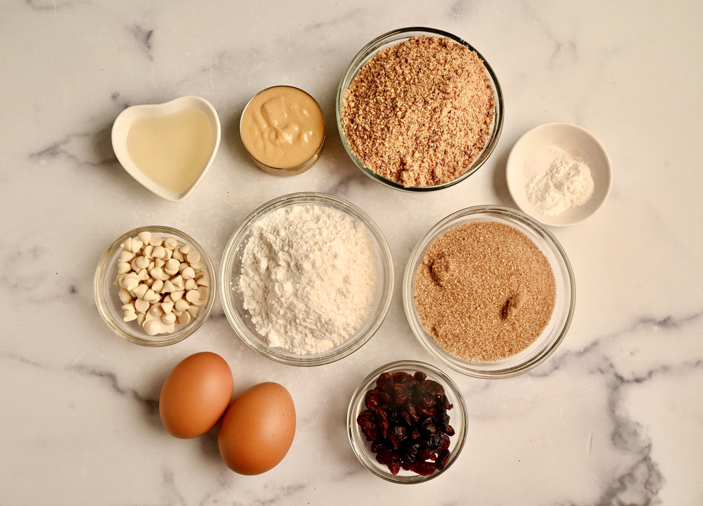 An overhead shot of raw ingredients in clear glass bowls on a kitchen counter