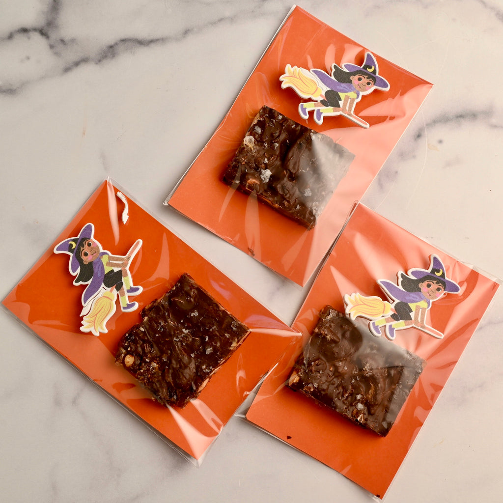 A square of homemade date bark wrapped in a Halloween plastic bag