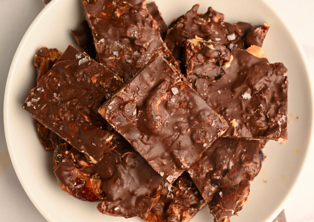 A plate of homemade date bark broken up into squares