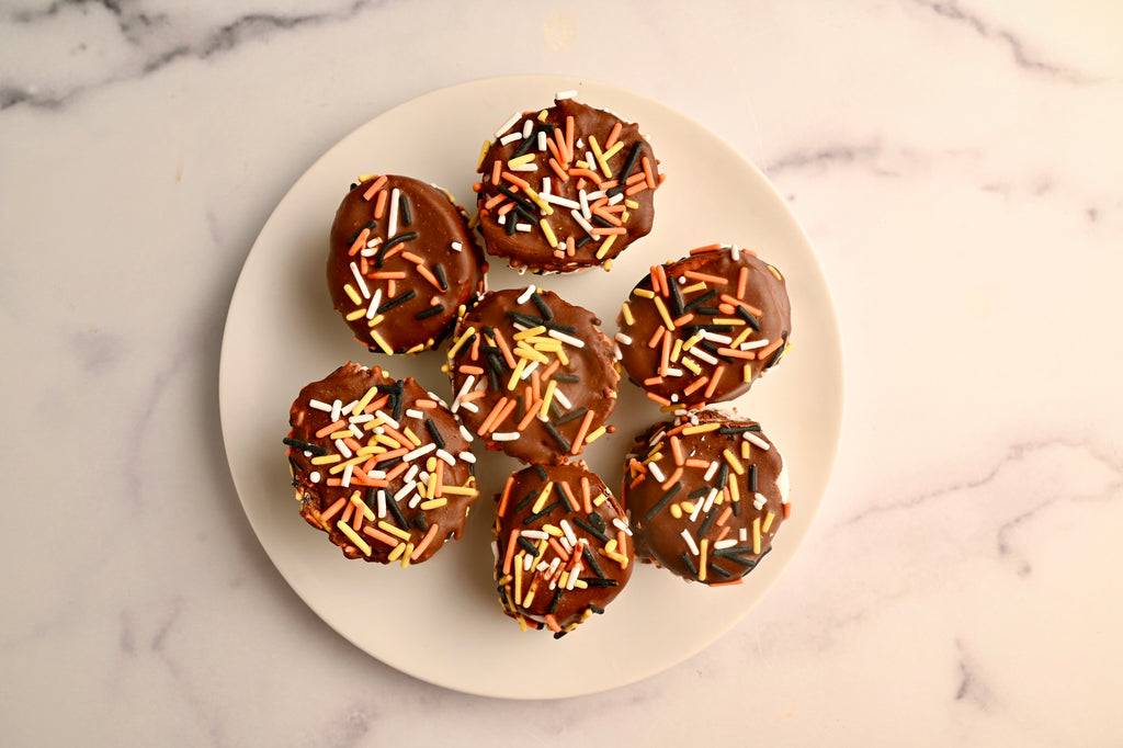 A plate of chocolate covered marshmallows with Halloween sprinkles